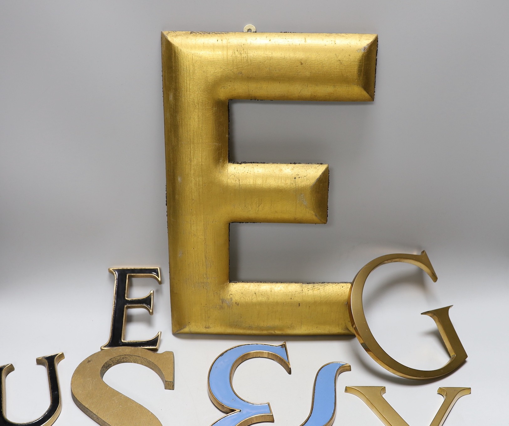 A collection of brass and enamelled lettering of varying sizes and fonts